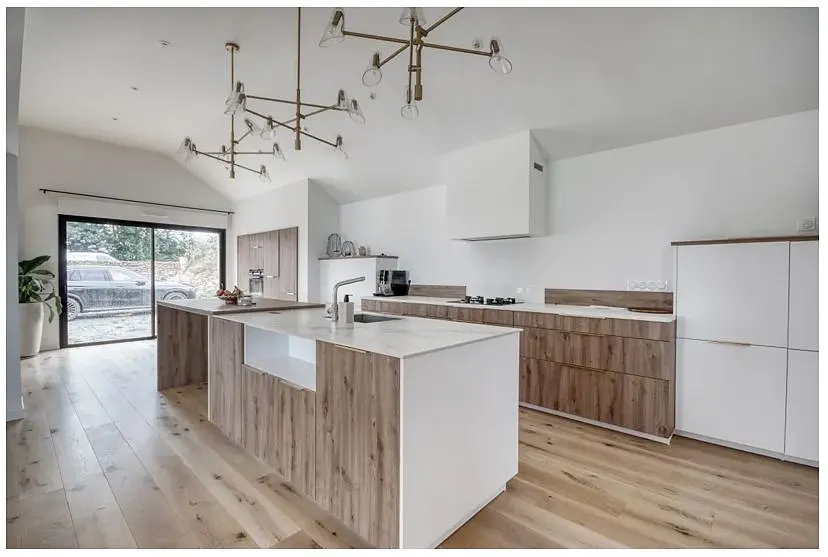 La cuisine : îlot central bois et pierre blanche, suspensions design